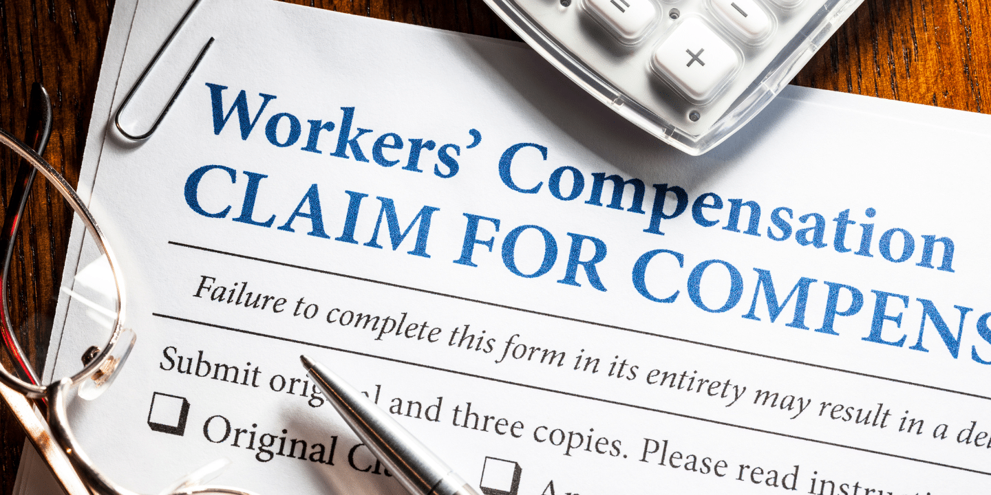 Workers' compensation settlement form and a calculator on the table