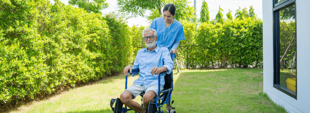 Avalon View Health And Wellness Brown Crouppen   Nurse Pushing An Elderly Man Outside In A Wheelchair 1024x373 