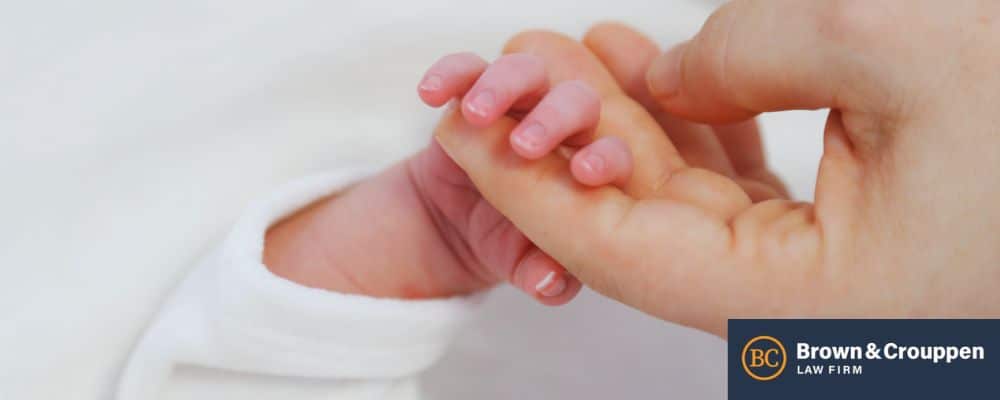 parent holding infant's hand after delivery